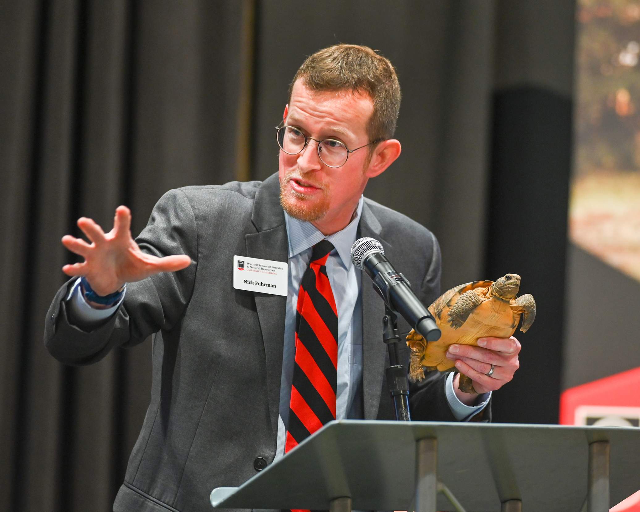 Faculty speaker Nick Fuhrman holds Sheldon the gopher tortoise