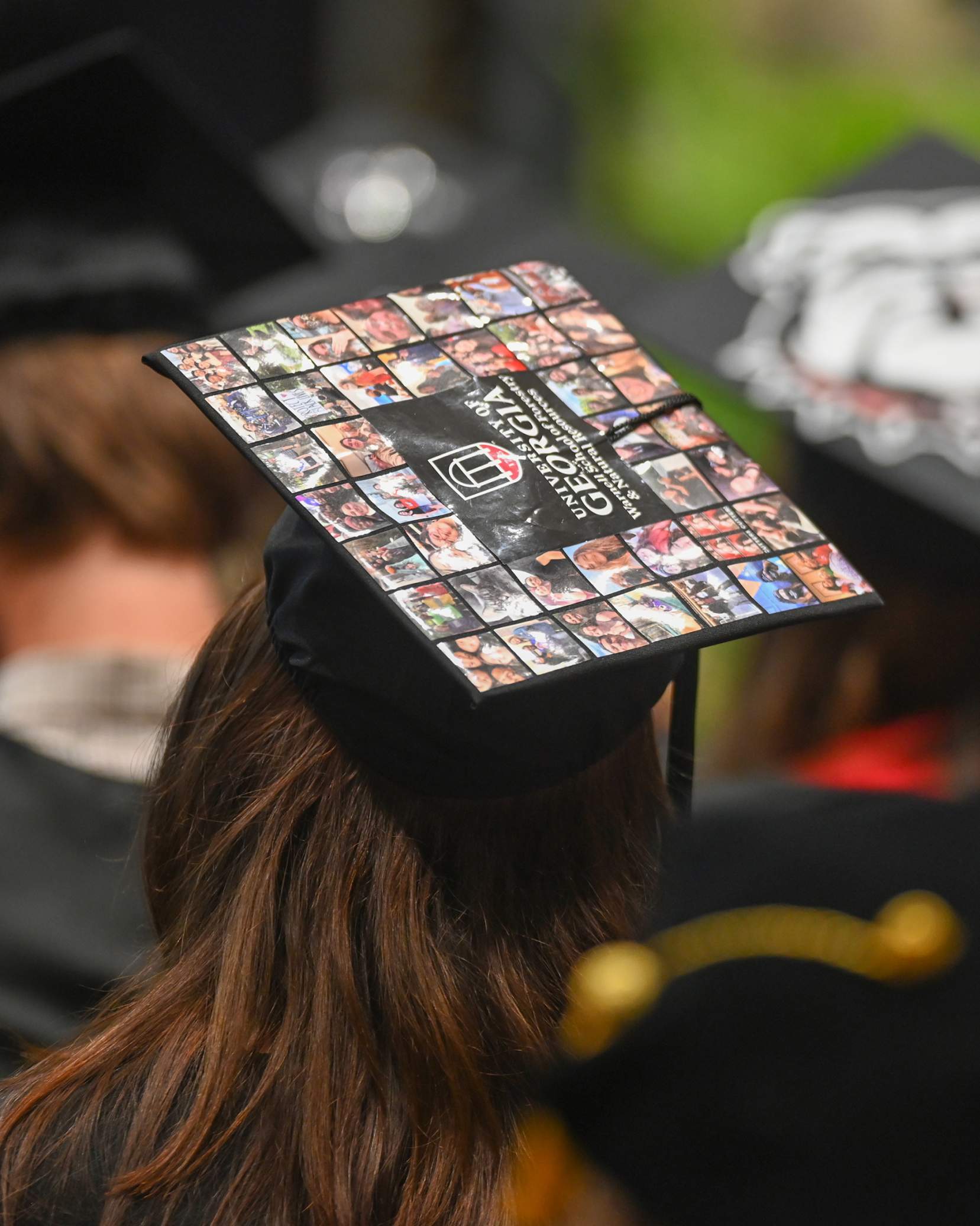 A student's cap is decorated with photos from high school and college