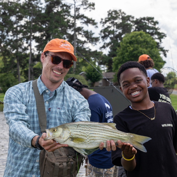 Volunteer with camper and catch