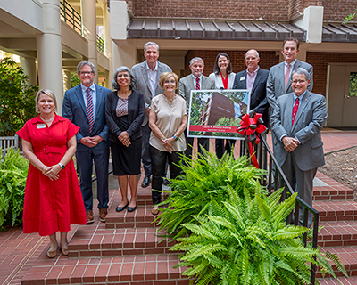 Group gathers for photo in front of Charles H. Wheatley Building