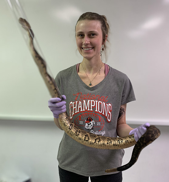 Corinna Hazelrig holds a snake in a tube