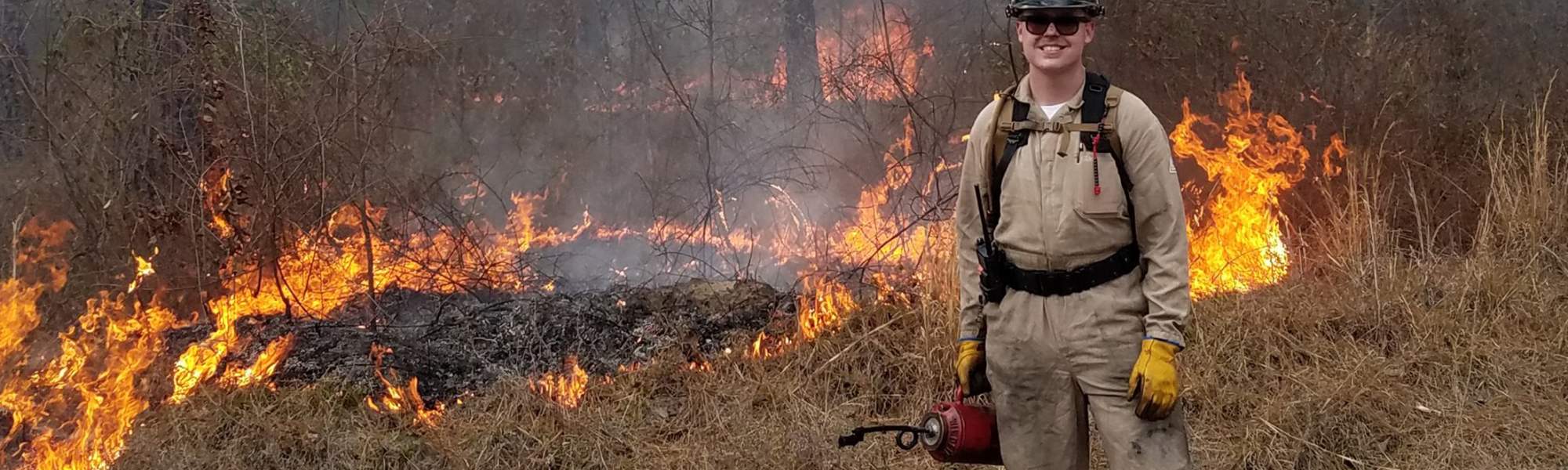 Jack Derochers stands in front of a prescribed burn