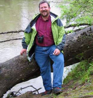 Gary Grossman stands next to a river