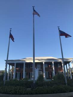 The governor's mansion is framed by flags