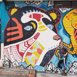 Hohbein stands next to a mural of a bear in Bogota.