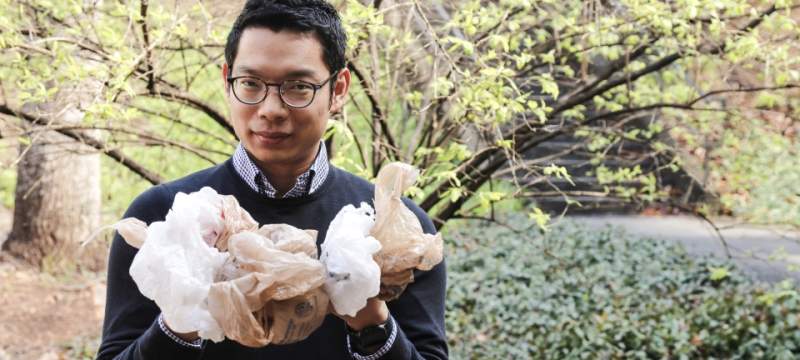 Yu-Kai Huang, a postdoctoral researcher at Warnell, stands outside holding some plastic shopping bags.
