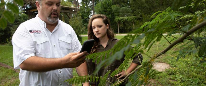 Chuck Bargeron demonstrates an invasive species app with Rachel Carroll