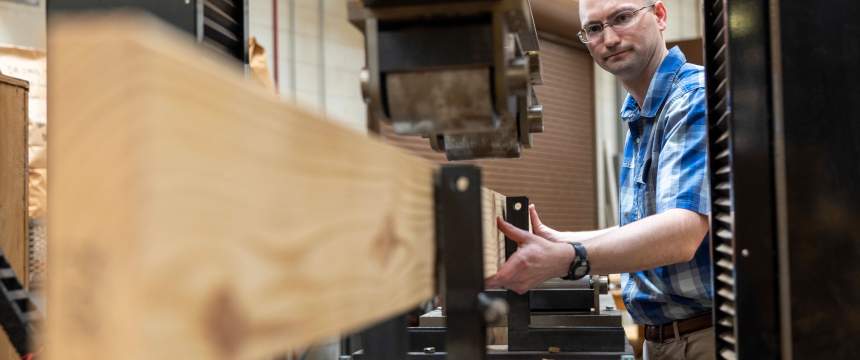 Joe Dahlen inserts a board into a device to measure its strength
