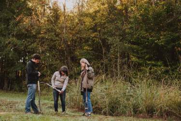 Students look at soil samples with a professor
