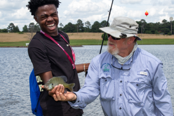 Jay Shelton shows camper how to hold fish properly