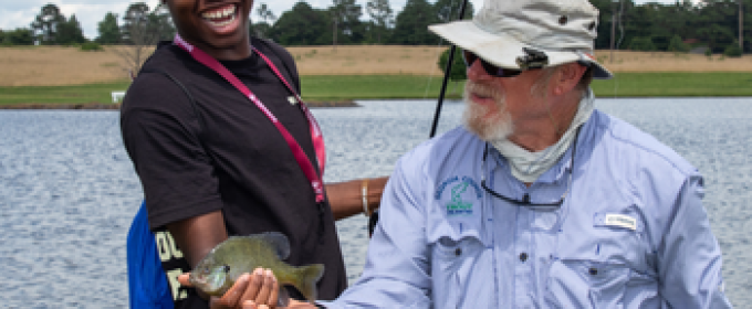 Jay Shelton shows camper how to hold fish properly