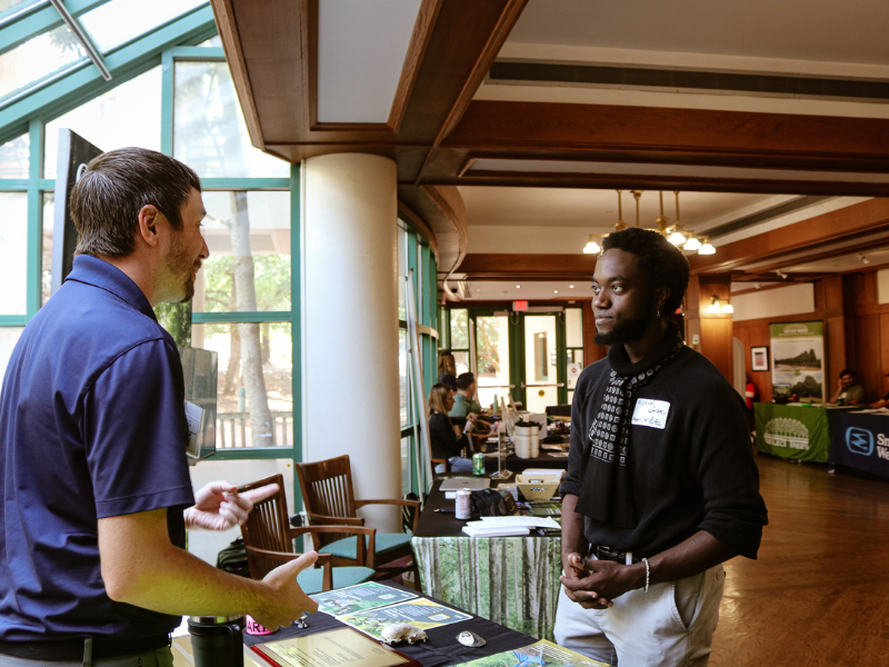 Preparing Leaders Image A student talking to a person at a job fair